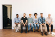 © dikushin - Wide shot of tired diverse multiethnic and different ages candidates for vacancy sitting on chairs in queue feeling nervous bored waits job interview turn, on white isolated background.