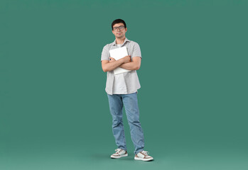Male programmer with laptop on green background