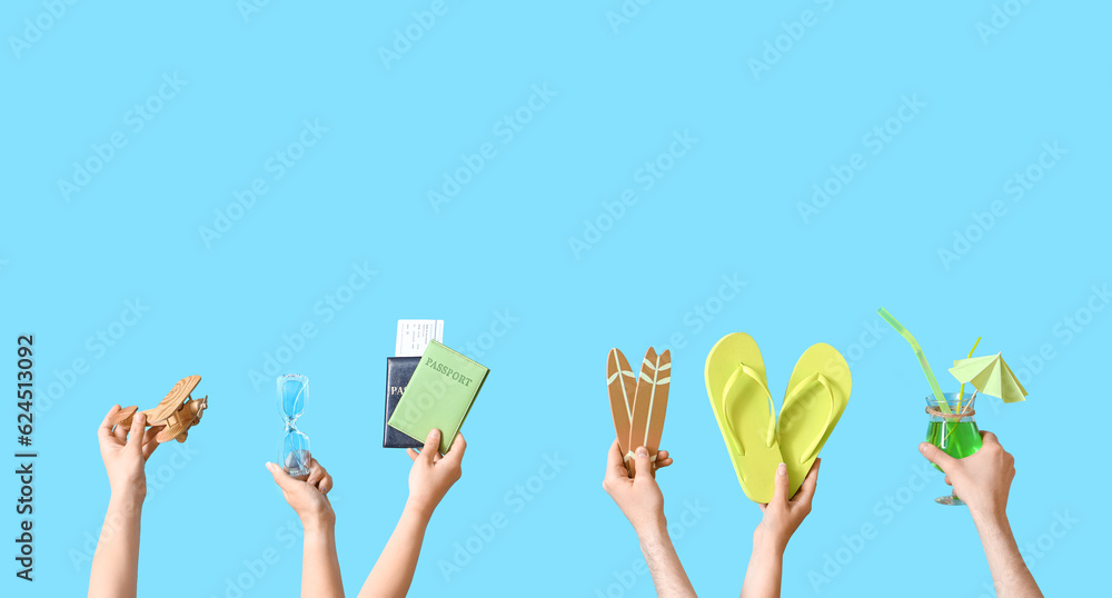 Many hands with beach accessories, passports and cocktail on blue background