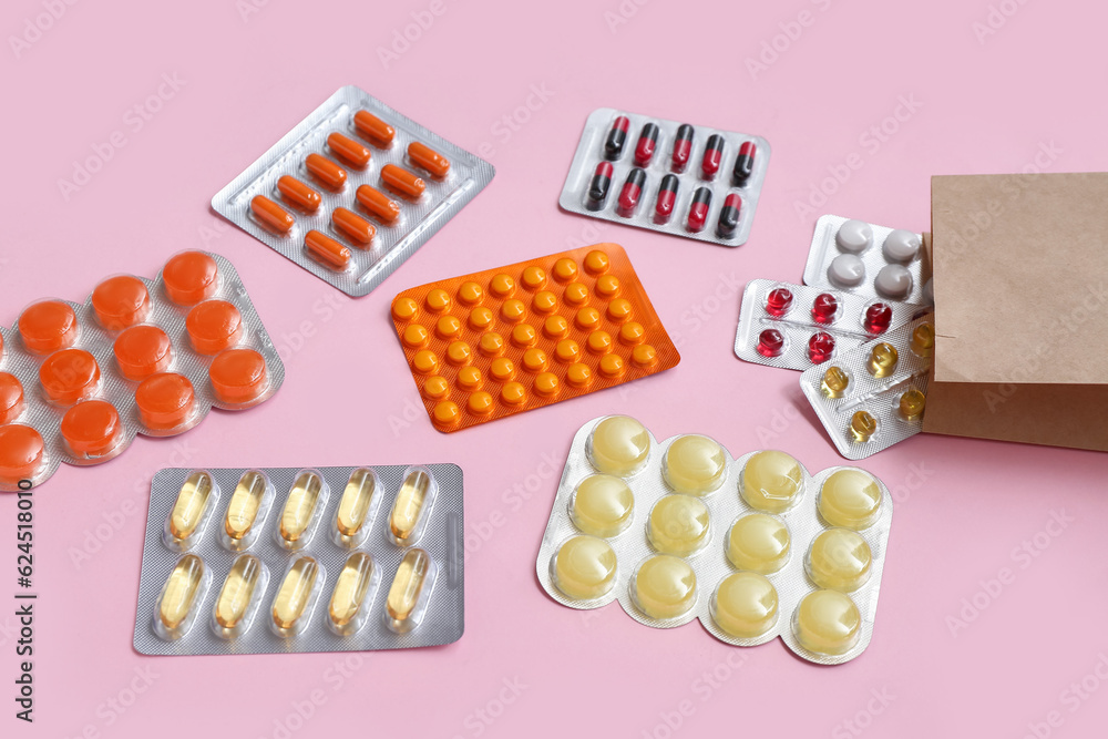 Shopping bag with different pills in blister packs on pink background