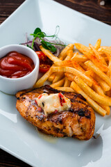 Wall Mural - Fried chicken fillet with French fries, onion, cherry tomatoes and ketchup, closeup.