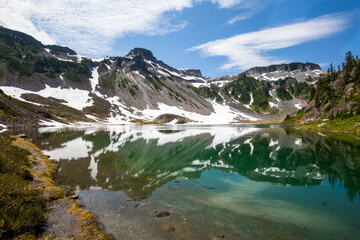 Wall Mural - Table Mountain, volcanic rock rising toward the sky and below, serene Upper Bagley Lake with a reflection of the mountain in summer