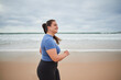 © Yakobchuk Olena - Motivated body positive sports woman jogging at the sandy sea beach