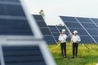 © Serhii - The solar farm(solar panel) with two engineers walk to check the operation of the system, Alternative energy to conserve the world's energy, Photovoltaic module idea for clean energy production
