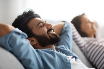 Wall Mural - Satisfied eastern young spouses resting at home