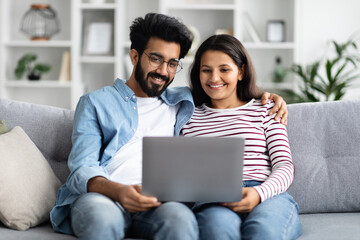 Wall Mural - Sweet hindu couple watching movie on laptop at home