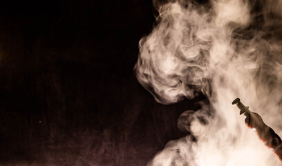 puffs of smoke on a black background and a hookah pipe