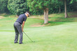 © buritora - ゴルフ場でアイアンショットをするゴルファーの男性