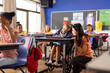 Diverse female teacher and schoolgirl in wheelchair in elementary school class
