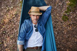 © baranq - Overhead portrait of handsome adult man lying in hammock in forest