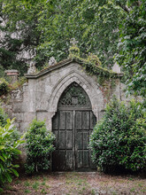 Medieval Stone And Wood Manor Gate Covered With Green Plants And Trees
