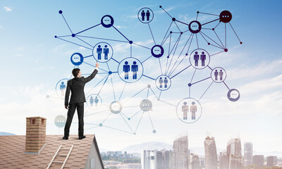 Wall Mural - businessman on house roof presenting networking and connection concept. mixed media