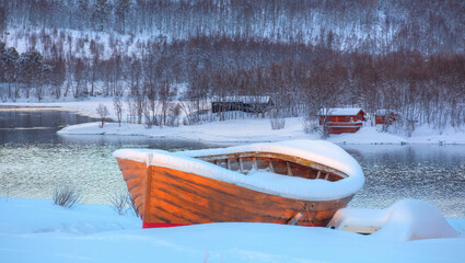 Wall Mural - beautiful winter landscape with old fishing red cabin (boathouse) boat at sunset - red wooden boatho