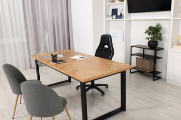 Canvas Print - Stylish director's workplace with wooden table and comfortable armchairs in office. Interior design