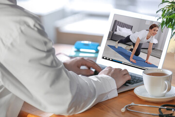 Poster - Man watching morning exercise video on laptop at home, closeup