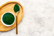 Dietary supplement for vegan Spirulina algae powder in bowl, top view