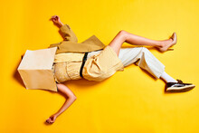 Man And Woman Body Combination. People In Retro Clothes Lying On Floor With Head Covered With Wallpaper Against Bright Yellow Background. Concept Of Creativity, Inspiration, Fashion, Ad. Pop Art
