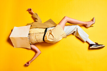 man and woman body combination. people in retro clothes lying on floor with head covered with wallpa