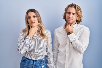 Poster - Young couple standing over blue background touching painful neck, sore throat for flu, clod and infection