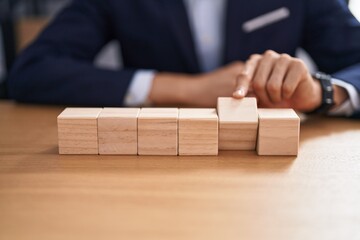 Sticker - Young blond man business worker sitting on table with wooden cubes at office