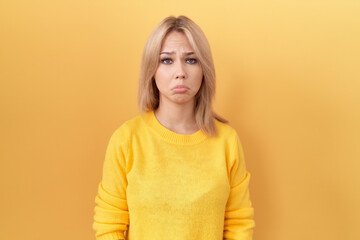 Poster - Young caucasian woman wearing yellow sweater depressed and worry for distress, crying angry and afraid. sad expression.