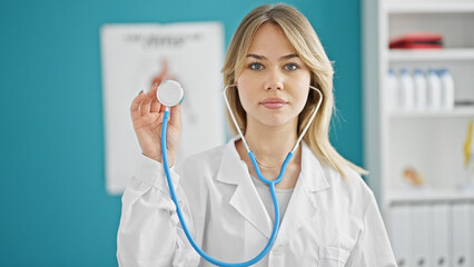 Poster - Young blonde woman doctor holding stethoscope at clinic