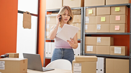 Poster - Young blonde woman ecommerce business worker talking on smartphone reading document at office