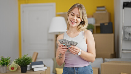 Poster - Young blonde woman smiling confident holding money at new home