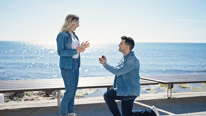 Poster - Man and woman couple smiling confident having engagement proposal at seaside