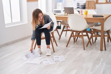 Young blonde woman reading a documents at office