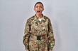 © Krakenimages.com - Beautiful african american woman wearing camouflage army uniform angry and mad screaming frustrated and furious, shouting with anger. rage and aggressive concept.