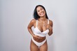 © Krakenimages.com - Hispanic woman wearing lingerie smiling and laughing hard out loud because funny crazy joke with hands on body.