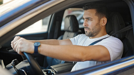 Wall Mural - Young hispanic man driving car at street