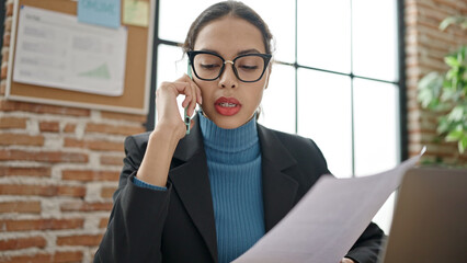 Sticker - Young beautiful hispanic woman business worker speaking on the phone reading document at office