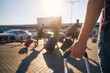 Group of people walking to airport terminal at summer sunset. Selective focus on hand of man with suitcase. .