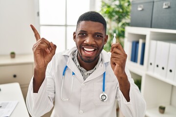 Poster - African american doctor man holding eye drops smiling happy pointing with hand and finger to the side