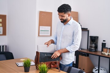 Wall Mural - Young arab man business worker smiling confident holding laptop at office