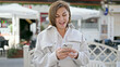 © Krakenimages.com - Middle age hispanic woman using smartphone at street