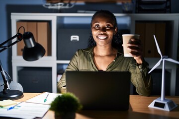 Poster - African woman working using computer laptop at night with a happy and cool smile on face. lucky person.