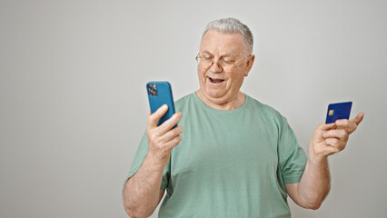 Canvas Print - Middle age grey-haired man shopping with smartphone and credit card surprised over isolated white background