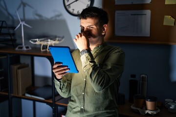 Sticker - Non binary person using touchpad device at night smelling something stinky and disgusting, intolerable smell, holding breath with fingers on nose. bad smell