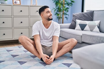 Wall Mural - Young arab man smiling confident stretching at home