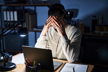 Poster - Young handsome man working using computer laptop at night suffering from headache desperate and stressed because pain and migraine. hands on head.