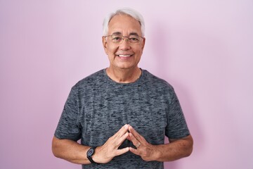 Sticker - Middle age man with grey hair standing over pink background hands together and fingers crossed smiling relaxed and cheerful. success and optimistic