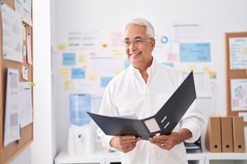 Wall Mural - Middle age grey-haired man business worker reading document at office