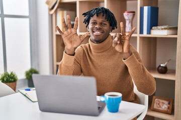 Sticker - Young african man with dreadlocks working using computer laptop showing and pointing up with fingers number seven while smiling confident and happy.