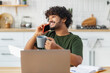 © kucherav - Portrait of successful Asian young male entrepreneur freelancer working, talking on mobile phone sitting in home office, looking away and smiles friendly