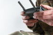 Soldier in military uniform holding drone remote control close-up. Concept of drones in modern war.