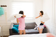Cheerful teenagers having a pillow fight at a slumber party