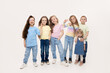 © oes - Group portrait of kids girls friends on white studio background. Happy children, cute girls hugging and having fun in carnival glasses. funny faces